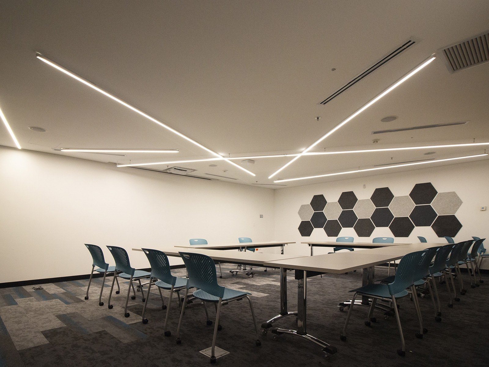 Sala de capacitación con luminarias lineales suspendidas